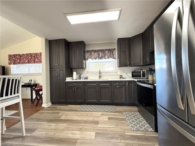 kitchen with sink, light hardwood / wood-style flooring, and stainless steel appliances