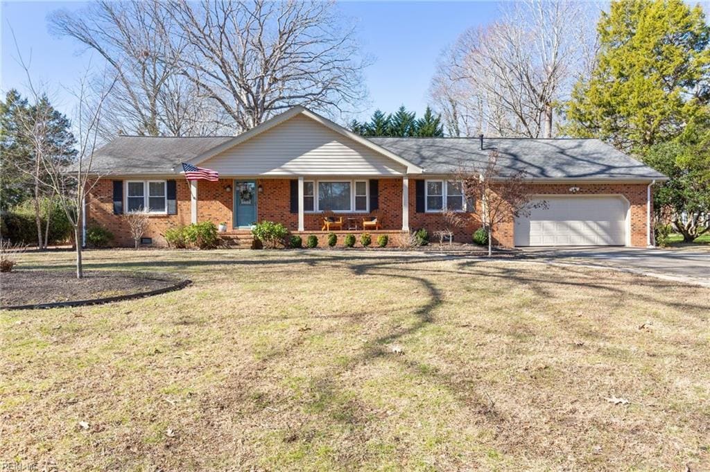 ranch-style house featuring a garage and a front lawn