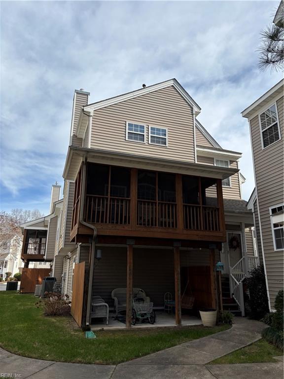 rear view of property featuring a patio area, central air condition unit, and a lawn