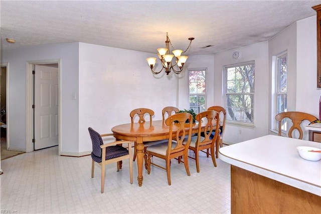 dining room with a chandelier and a textured ceiling