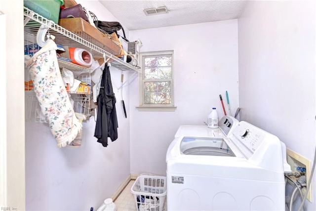 laundry room with a textured ceiling and washer and clothes dryer