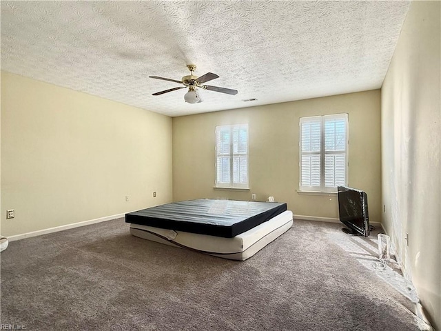 unfurnished bedroom with ceiling fan, carpet, and a textured ceiling