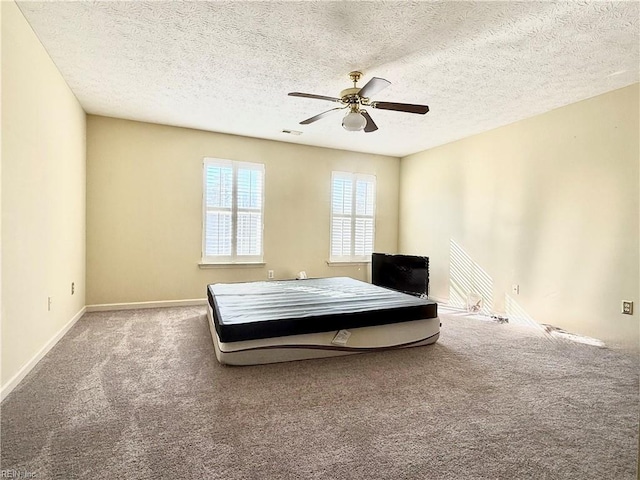 unfurnished bedroom featuring carpet, a textured ceiling, and ceiling fan