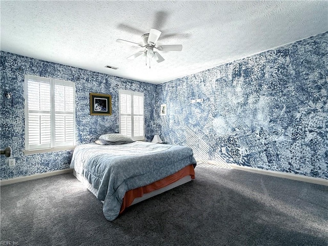 carpeted bedroom featuring ceiling fan and a textured ceiling