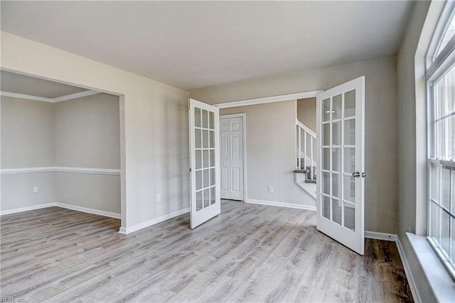 empty room featuring light hardwood / wood-style floors and french doors