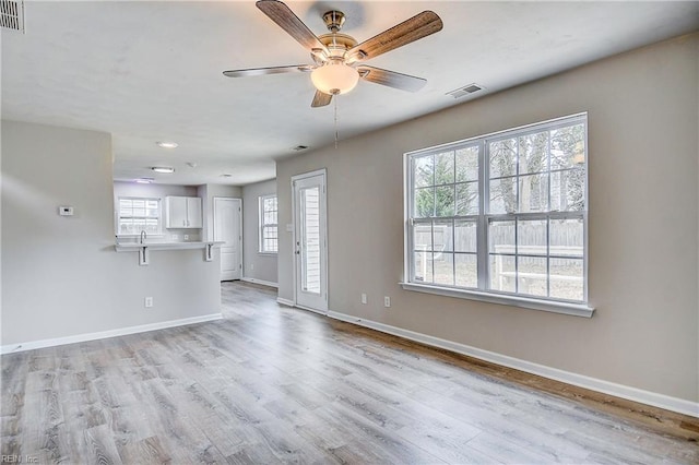 unfurnished living room featuring ceiling fan and light wood-type flooring