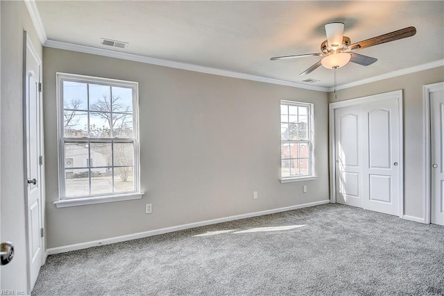 unfurnished bedroom with ornamental molding, carpet, and ceiling fan