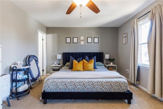 carpeted bedroom featuring ceiling fan and a textured ceiling