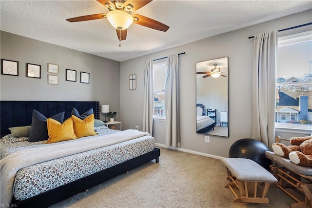 carpeted bedroom with ceiling fan and a textured ceiling