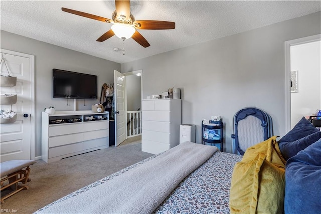 carpeted bedroom featuring ceiling fan and a textured ceiling