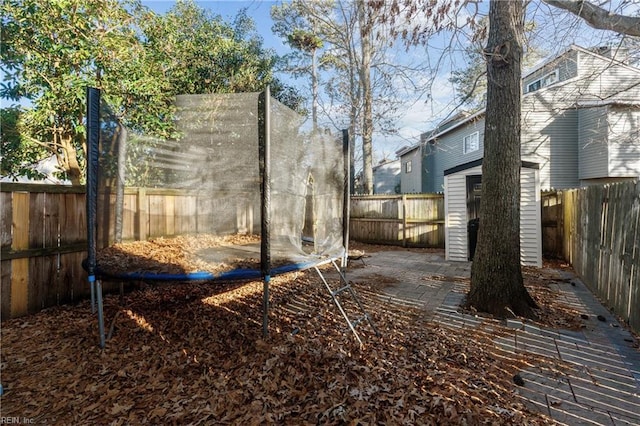 view of yard with a trampoline and a shed