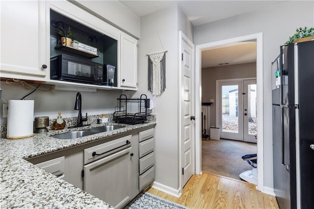 kitchen with white cabinetry, light stone countertops, sink, and black appliances