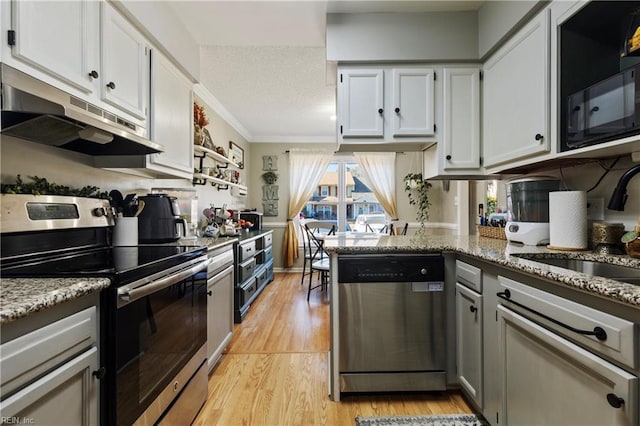 kitchen with light stone countertops, appliances with stainless steel finishes, and white cabinets