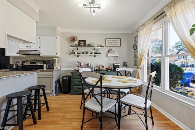 dining space featuring crown molding, light hardwood / wood-style floors, and a textured ceiling