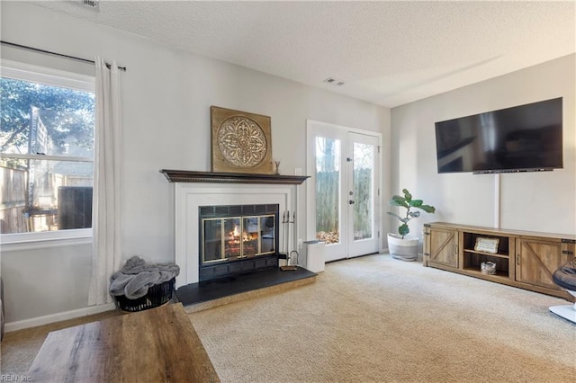 living room with french doors, a textured ceiling, and carpet