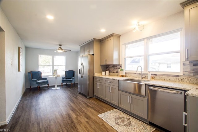 kitchen with tasteful backsplash, sink, gray cabinetry, dark hardwood / wood-style flooring, and stainless steel appliances