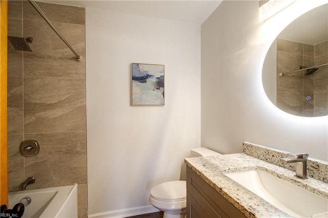 full bathroom featuring tiled shower / bath, vanity, and toilet