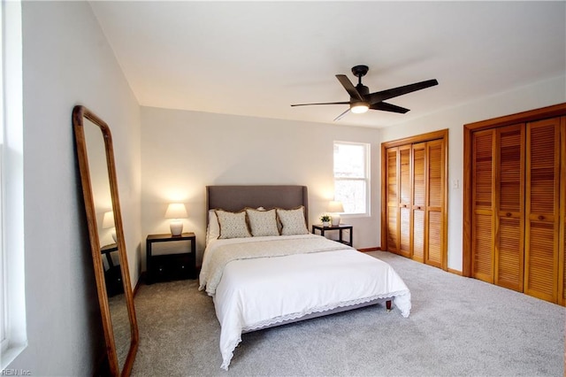 carpeted bedroom with multiple closets and ceiling fan