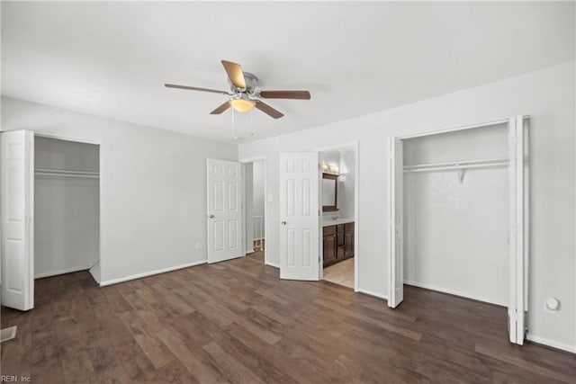 unfurnished bedroom featuring ceiling fan, connected bathroom, two closets, and dark hardwood / wood-style flooring