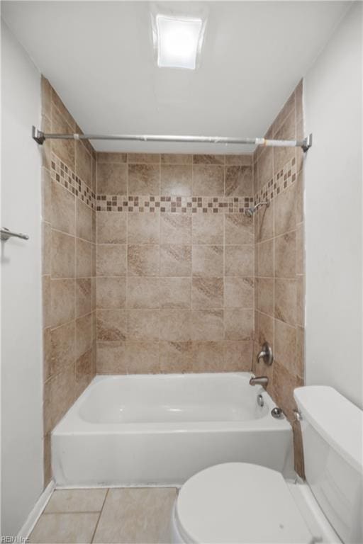 bathroom featuring tiled shower / bath combo, tile patterned floors, and toilet