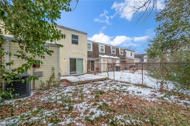 snow covered back of property featuring a wooden deck and central AC unit