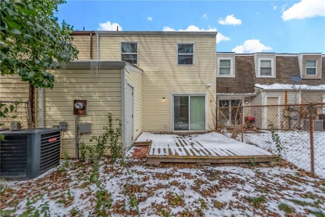 snow covered rear of property featuring a wooden deck and central AC