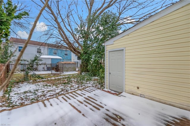 snowy yard featuring an outbuilding