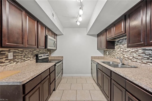 kitchen featuring stainless steel appliances, light tile patterned flooring, sink, and dark brown cabinetry