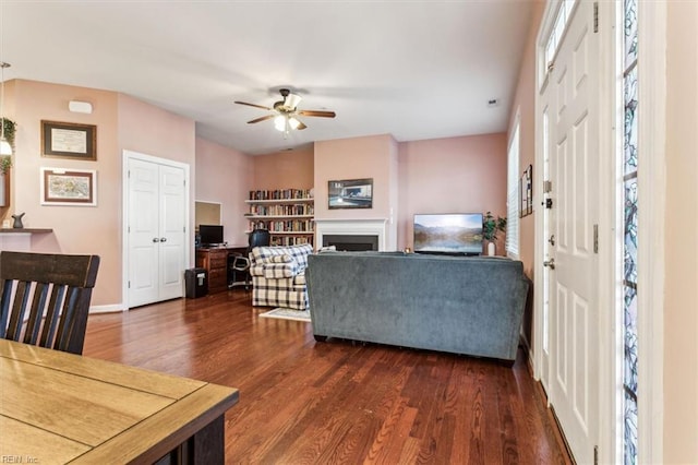 living room with ceiling fan and dark hardwood / wood-style floors