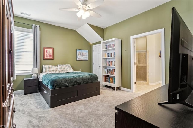 carpeted bedroom with ensuite bath and ceiling fan