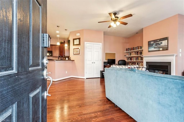 living room with ceiling fan and dark hardwood / wood-style flooring