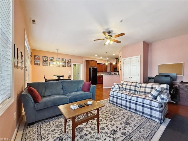 living room with ceiling fan and dark hardwood / wood-style flooring