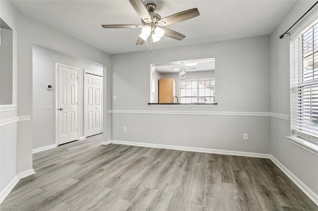 empty room with hardwood / wood-style floors and ceiling fan