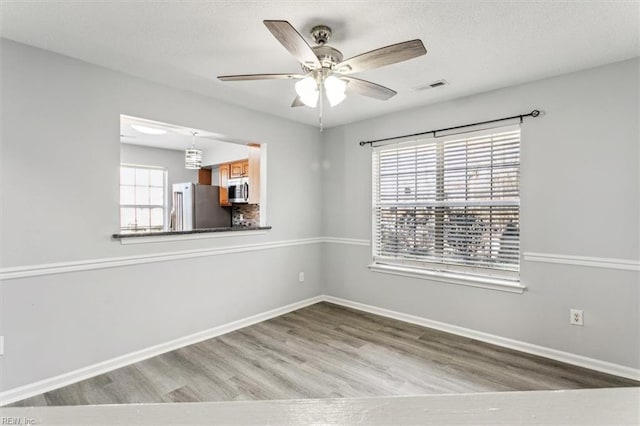 spare room with ceiling fan and light hardwood / wood-style floors