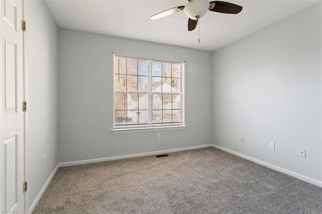 carpeted spare room featuring ceiling fan