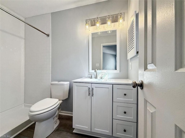 bathroom featuring vanity, toilet, hardwood / wood-style floors, and a shower