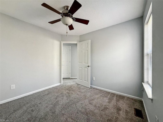 spare room with ceiling fan, carpet floors, and a textured ceiling