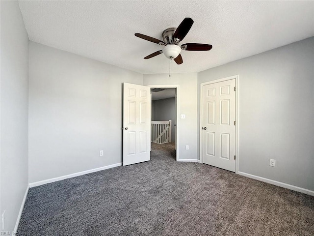 unfurnished bedroom with ceiling fan, a textured ceiling, and dark colored carpet