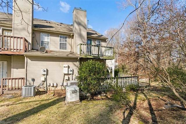 rear view of house with a wooden deck, a yard, and central AC