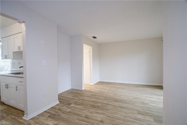 empty room with sink and light wood-type flooring