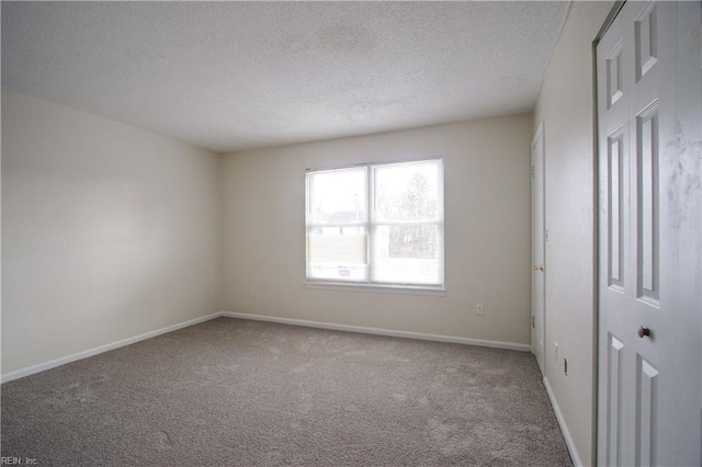 spare room featuring a textured ceiling and carpet flooring