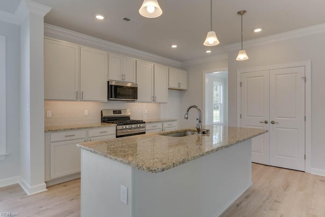 kitchen with sink, stainless steel appliances, an island with sink, and white cabinets