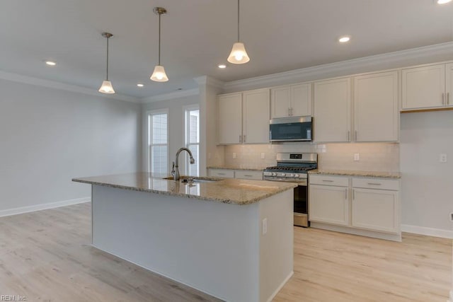 kitchen featuring pendant lighting, sink, a kitchen island with sink, white cabinetry, and stainless steel appliances