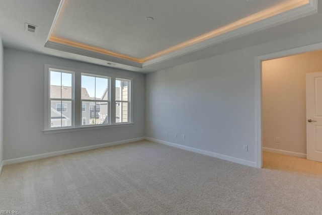 carpeted empty room featuring a raised ceiling