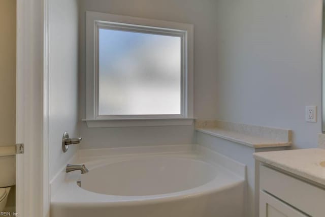 bathroom with vanity, toilet, and a washtub