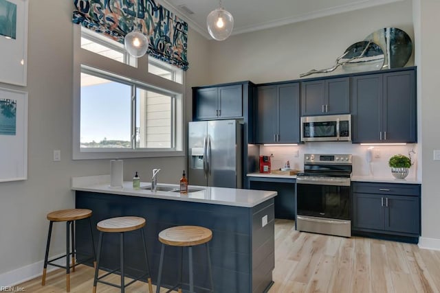 kitchen with sink, a kitchen breakfast bar, stainless steel appliances, light hardwood / wood-style floors, and kitchen peninsula