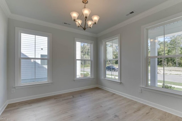 unfurnished dining area with ornamental molding, a chandelier, and light hardwood / wood-style flooring