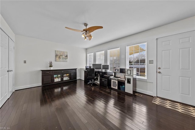 home office with dark wood-type flooring and ceiling fan