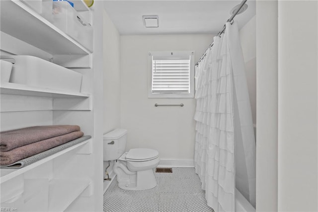 bathroom with tile patterned flooring, toilet, and walk in shower