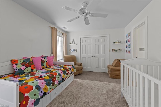 bedroom with ceiling fan, light colored carpet, and a closet